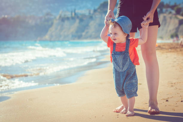 istock Baby learning to walk on the beach 951176656