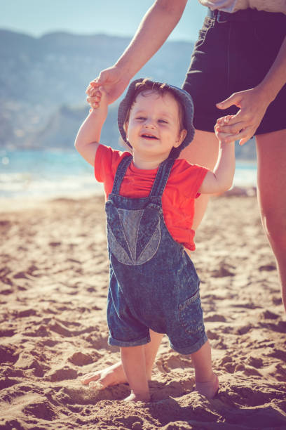 istock Baby learning to walk on the beach 951177066