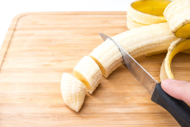 istock male hands Cutting Banana on the kitchen board. Close-up. Selective Focus. 951177552