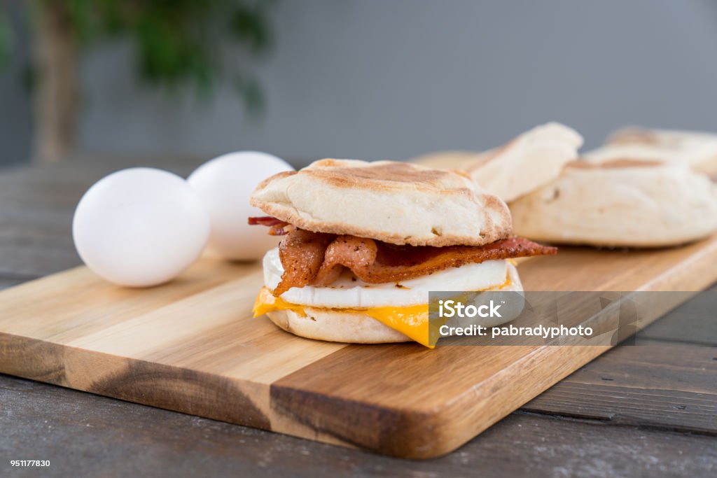 Panino per la colazione a base di pancetta, uova e formaggio - Foto stock royalty-free di Muffin - Pane