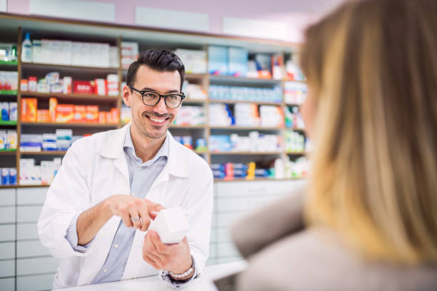 istock Male pharmacist serving a female customer. 951178526