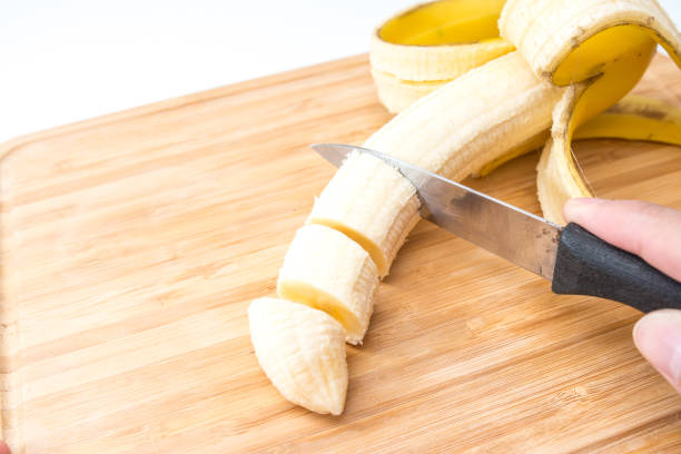 istock male hands Cutting Banana on the kitchen board. Close-up. Selective Focus. 951179060