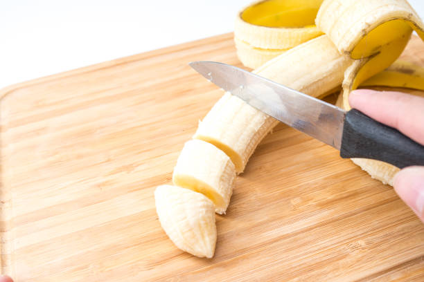 istock male hands Cutting Banana on the kitchen board. Close-up. Selective Focus. 951179200