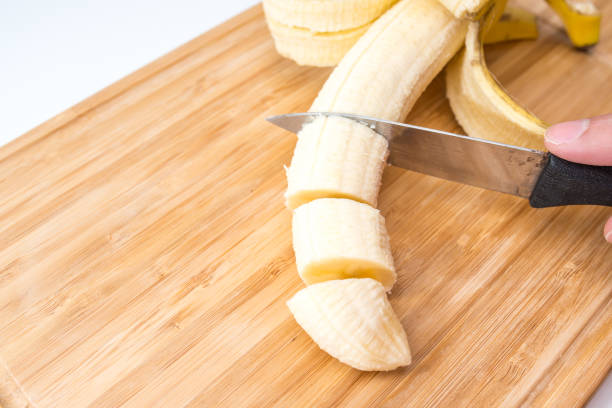 istock male hands Cutting Banana on the kitchen board. Close-up. Selective Focus. 951180844