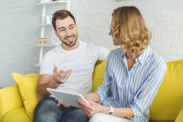 istock Smiling man talking to girlfriend with tablet in hands 951188204