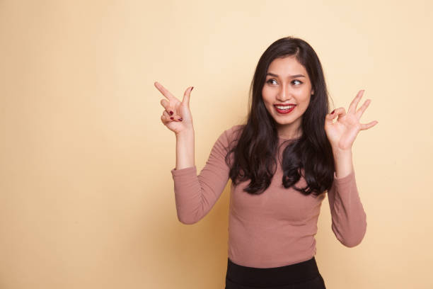 istock Young Asian woman point and show OK. 951188588