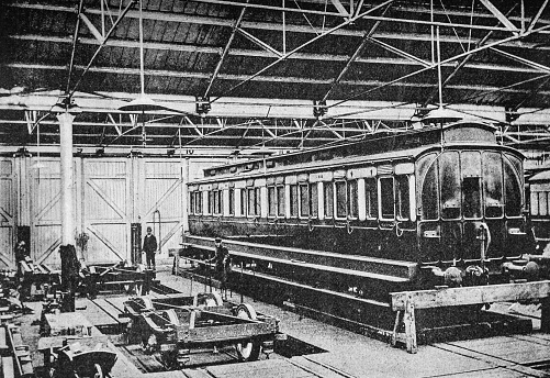 Constructing a train carriage in a workshop. Heavy industry inside a train yard in Swindon from the pre-1900 book \