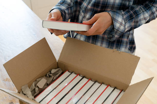 autore apre pacchetto con campioni del suo nuovo libro e controlla la copertina rigida - author foto e immagini stock