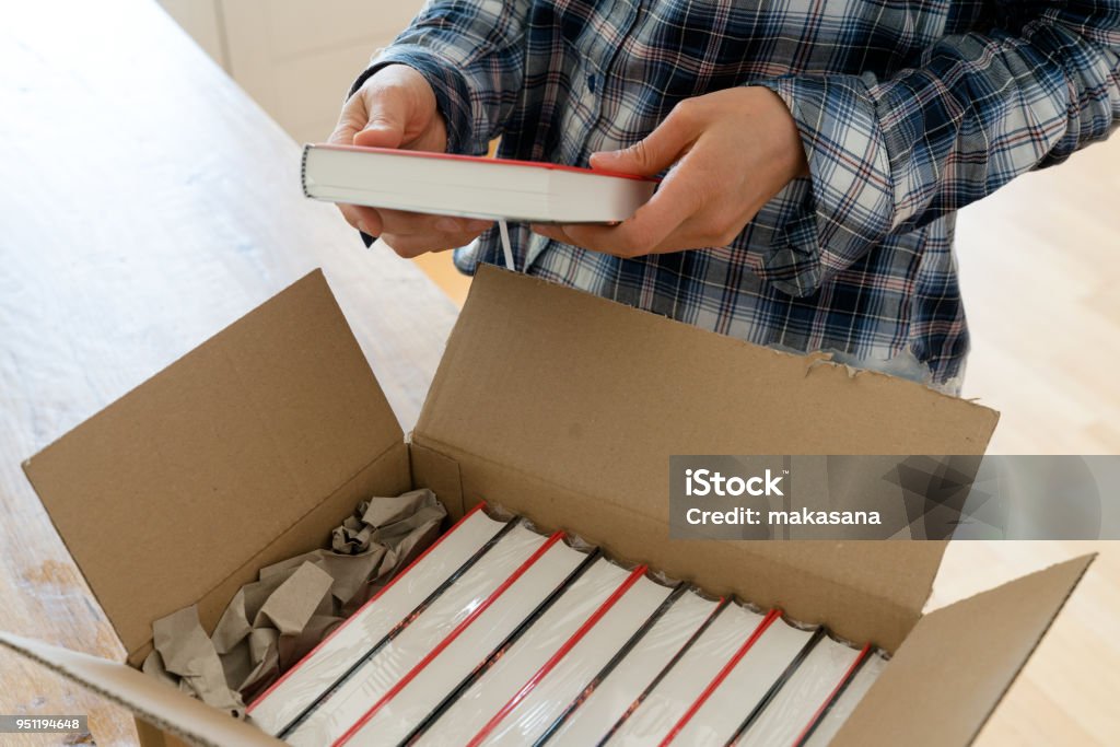 author opens package with samples of her new book and checks the hardcover author opens package with samples of her new book and checks the hardcover edition carefully Book Stock Photo