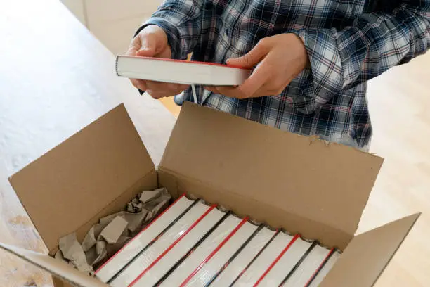 Photo of author opens package with samples of her new book and checks the hardcover