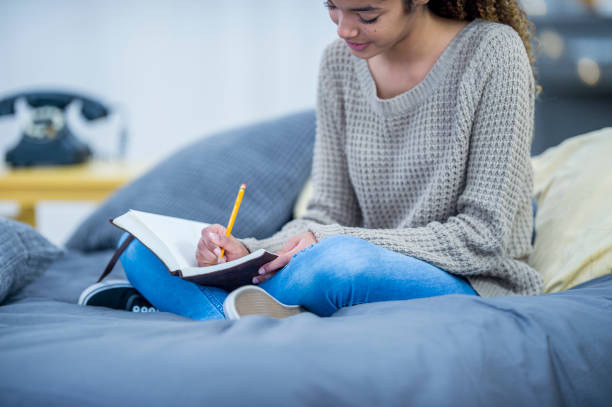 istock Girl Writing In A Book 951200276