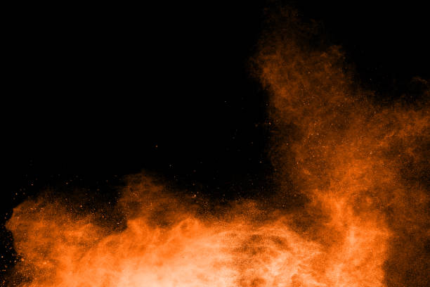 istock abstract orange dust explosion on  black background. abstract orange powder splattered on black background, Freeze motion of orange powder splash. 951205410