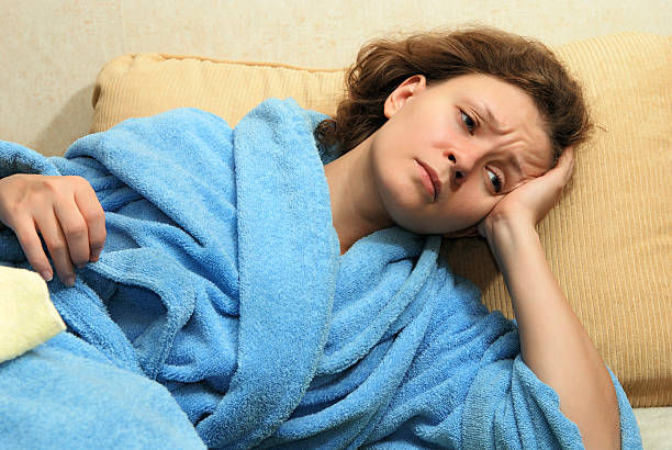 istock Woman in robe on couch with headache 95120613