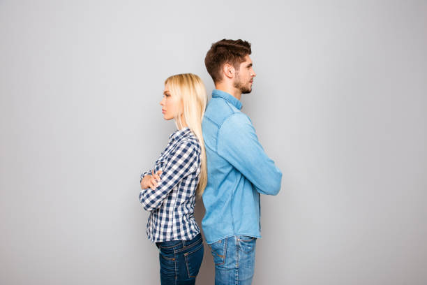 istock Man and woman with crossed hands standing back to back 951206192