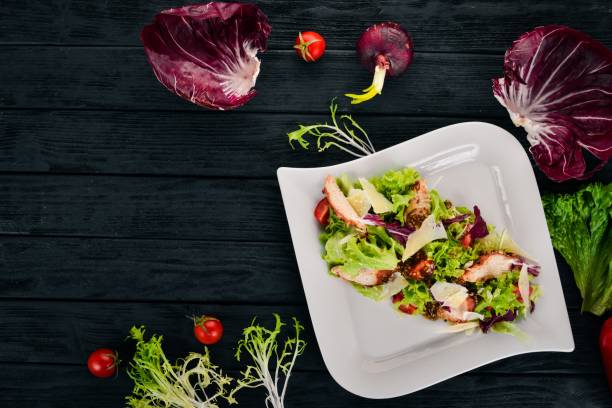 istock Caesar salad with chicken. Top view. On a wooden background. Copy space. 951215704
