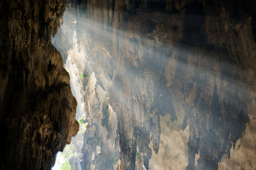 Rays of sunlight fall on the wall of cave. Concept of hope, discovery.