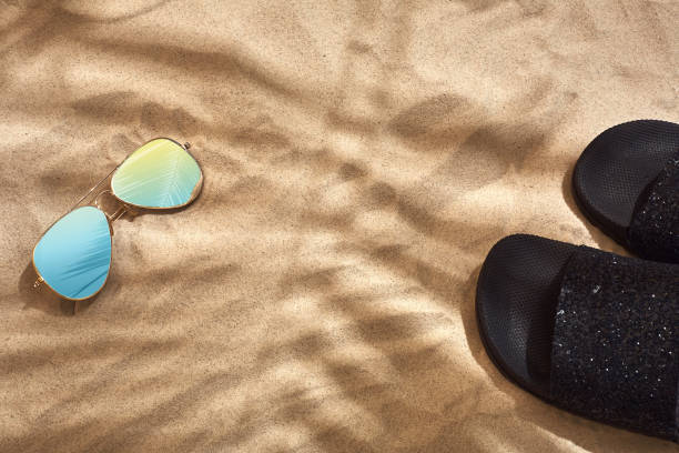 istock Sandal and sunglasses on a sandy background, top view 951223304