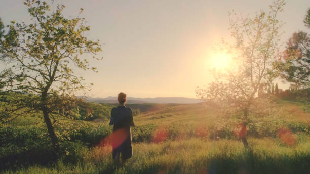 Young woman looking at sunset over Tuscany hills