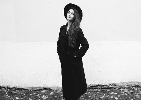 Beautiful woman in black coat street portrait fashion. Black and white. Outdoor shot.