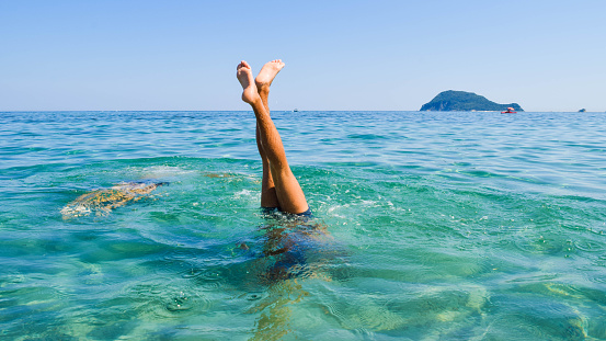 Dive into the sea with your feet up. Beach fun.