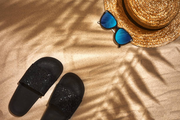 istock Sandal, straw hat and sunglasses on a sandy background, top view 951234392