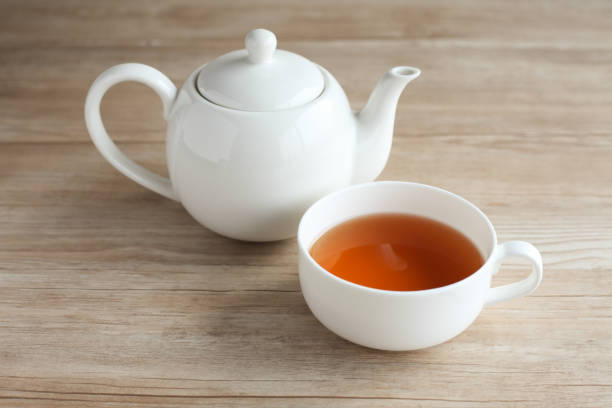 cup of tea and tea pot isolated on wood table