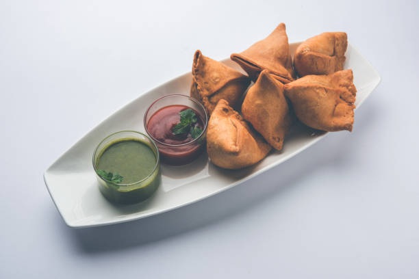 istock Veg Samosa is a triangle shape pakora stuffed with Aloo sabji, served with green chutney and tomato sauce. selective focus 951236108