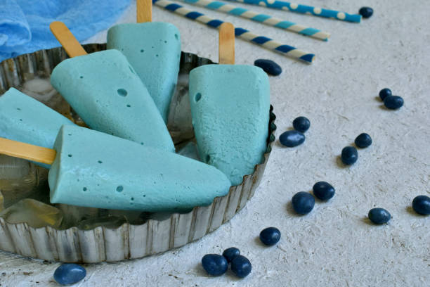 istock Blue ice cream pops with blueberry fruits on white background. Cool refreshing turquoise Italian dessert. Space for text 951238968