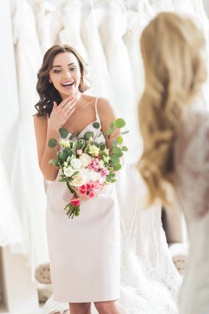 istock Pretty bridesmaid looking at bride in wedding salon 951242316