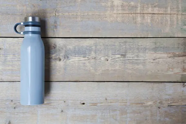 Photo of Stainless steel water bottle on wooden table