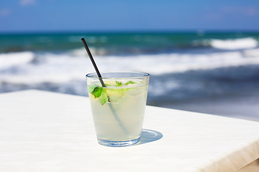 Cocktail glass on sea background. Mojito
