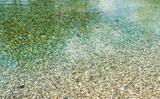 Italy,24 April 2018,spring water, clear surface with mountain pebbles,background wallpaper texture