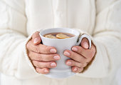 Close up of female hands holding cup of tea