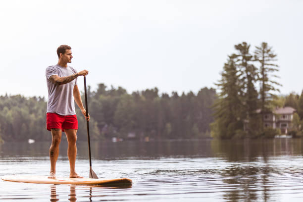 istock SUP Stand-up Paddleboard. A man is paddleboarding and rowing on a lake 951270126