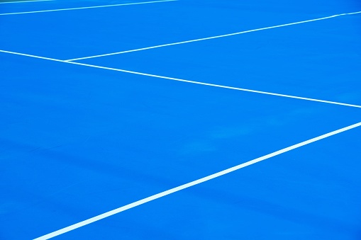 White diagonal lines on blue outdoor tennis court.