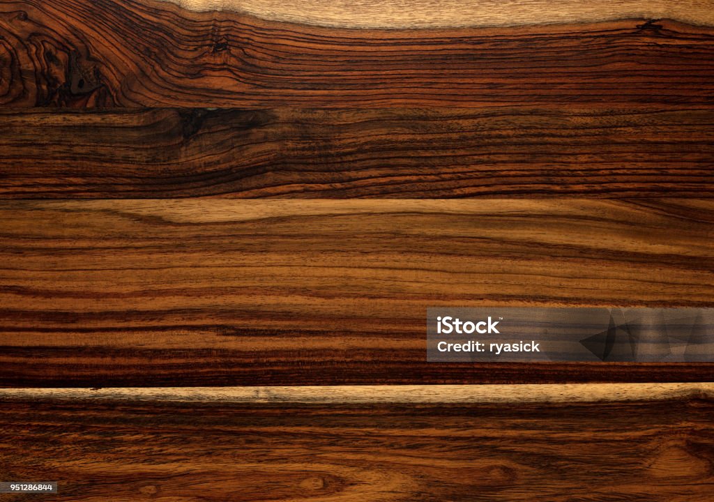 Brazilian Rosewood Background Texture Closeup of panels of Brazilian Rosewood background surface showing light and dark patterns of wood grain texture. Wood Grain Stock Photo