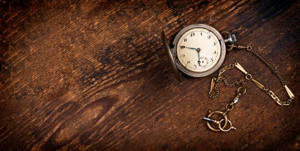 Vintage pocket watch on wooden table Vintage pocket watch on wooden table bronze colored photos stock pictures, royalty-free photos & images