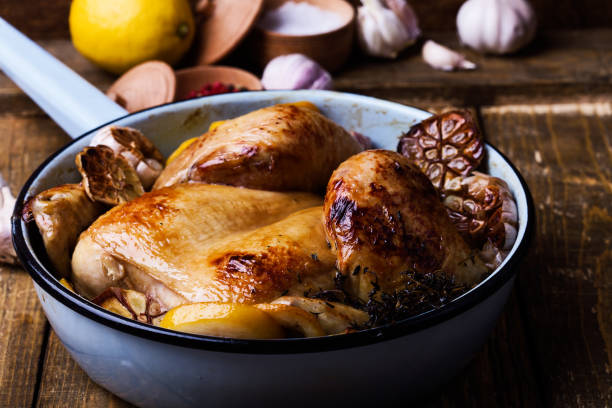 istock Roast chicken with garlic, thyme and lemon in cooking pan 951295674