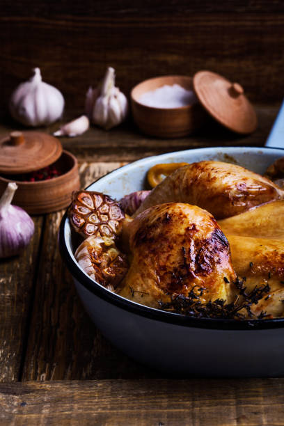 istock Roast chicken with garlic, thyme and lemon in cooking pan 951295684