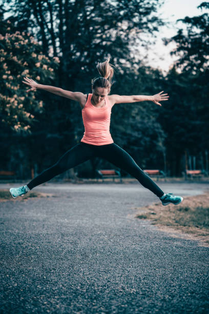 istock Young Women Doing Her Daily Exercises and Jumping in Park 951299178