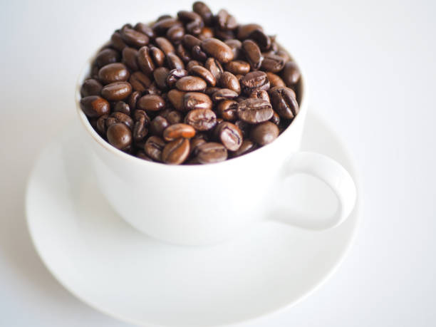 istock coffee with a white cup and brown beans on a saucer 951306818