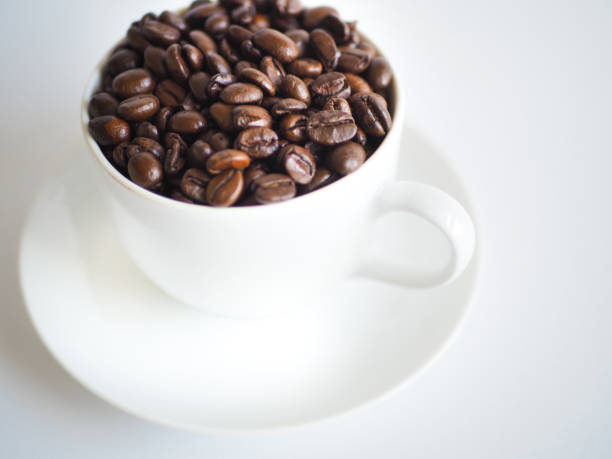 istock coffee with a white cup and brown beans on a saucer 951306822