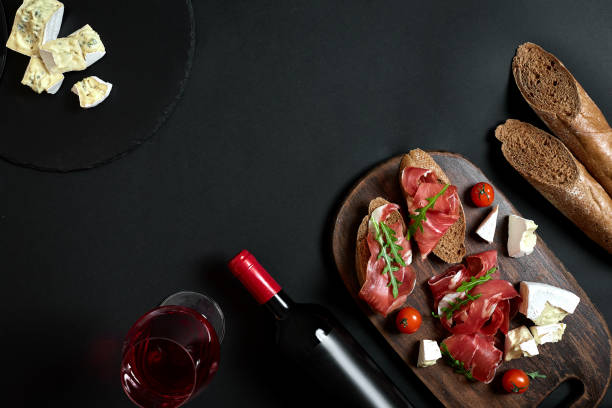치즈와 검은 배경 복사 공간에 나무 보드에 전통적인 소시지와 와인 병 - cheese wine food parmesan cheese 뉴스 사진 이미지