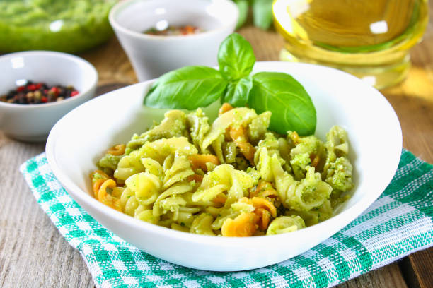 istock Pasta with pesto sauce on an old wooden table. 951315754
