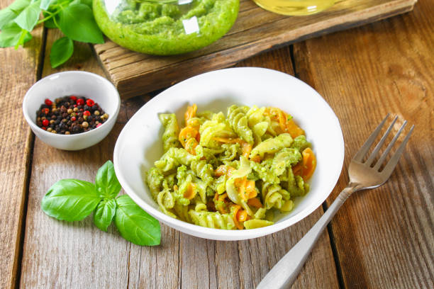 istock Pasta with pesto sauce on an old wooden table. 951315770