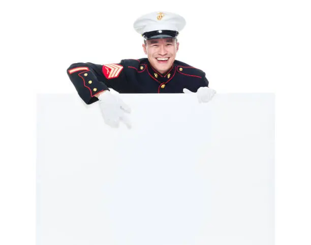 Photo of US Marine in uniform holding placard