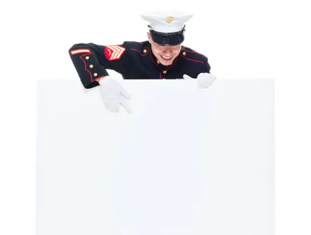 Photo of US Marine in uniform holding placard