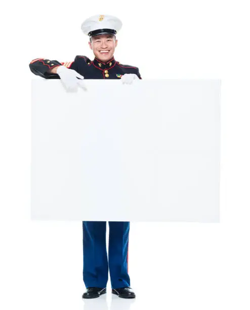 Photo of US Marine in uniform holding placard