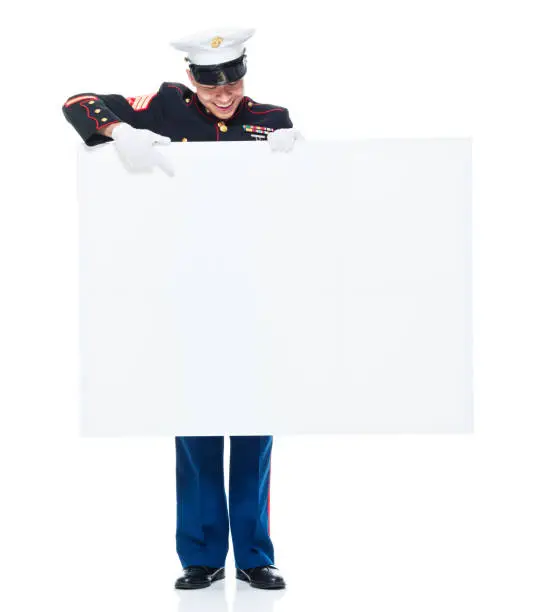Photo of US Marine in uniform holding placard