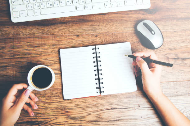 istock woman hand notepad with coffee and keyboard 951321992